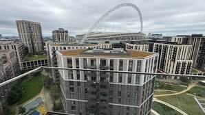 Un edificio de gran altura con un diseño arquitectónico moderno, que presenta una estructura curva destacada al fondo.
