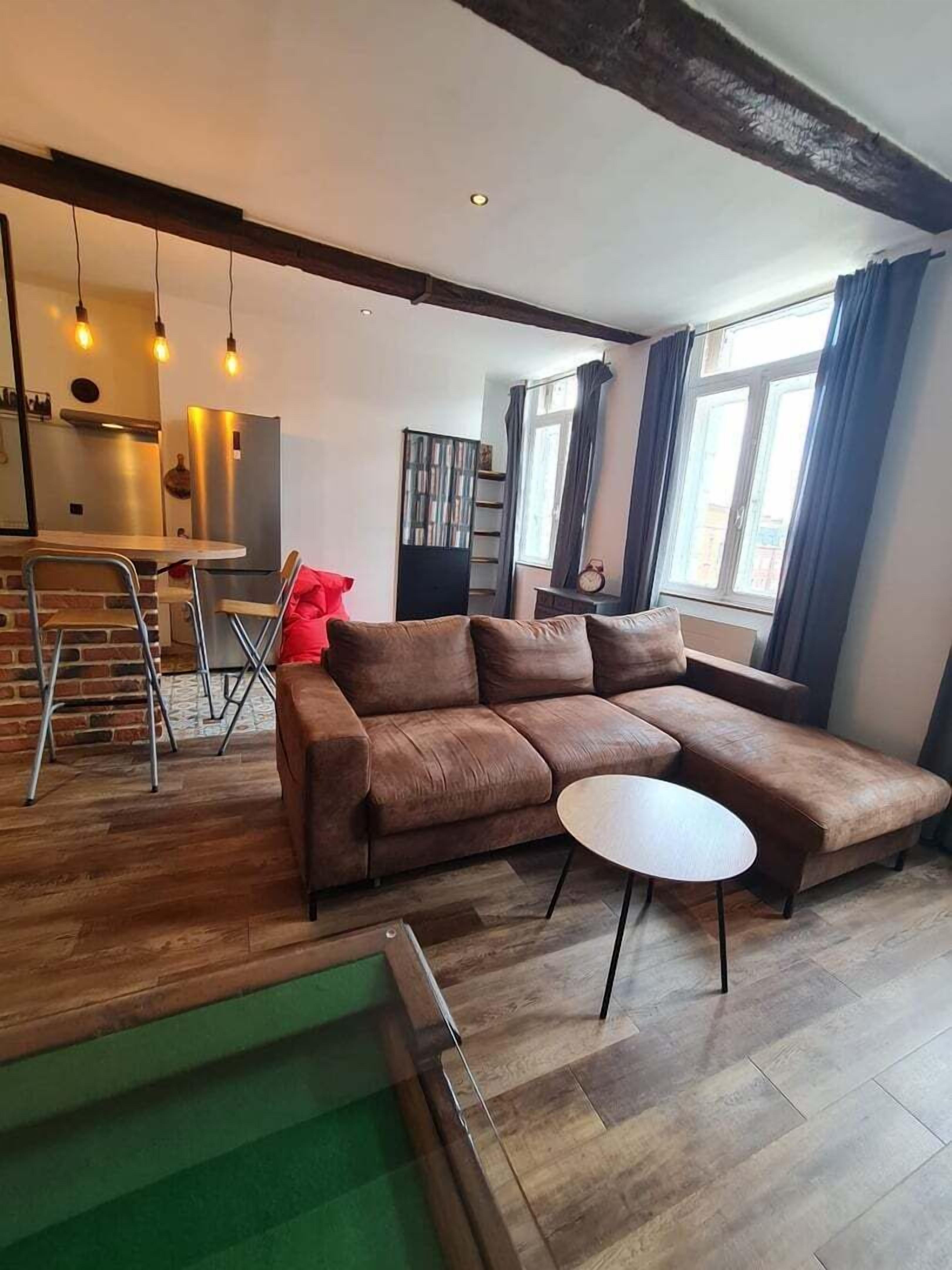 Een moderne woonkamer met een hoekbank, een klein rond tafeltje en een zwembad.
