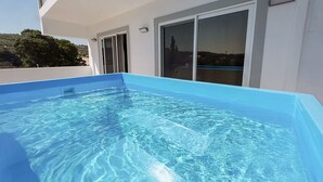 A rectangular swimming pool with clear blue water, adjacent to a building with large windows and a door. - Sinani Villas Rhodes - Private Pool Getaway (Rhodes)