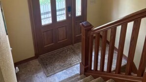 Una escalera de madera que conduce a una puerta con vidrieras.