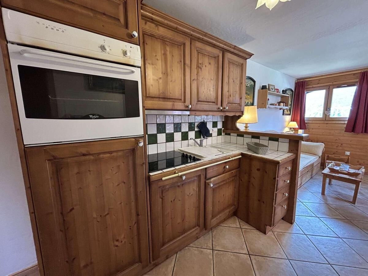 A kitchen with wooden cabinets, a white stove, and a tiled backsplash.