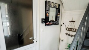 A staircase with a wooden handrail and a white door with a frosted glass panel.