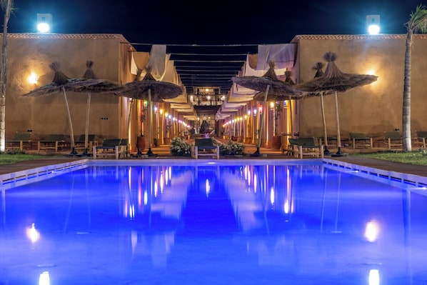 Una piscina al aire libre, sombrillas, tumbonas