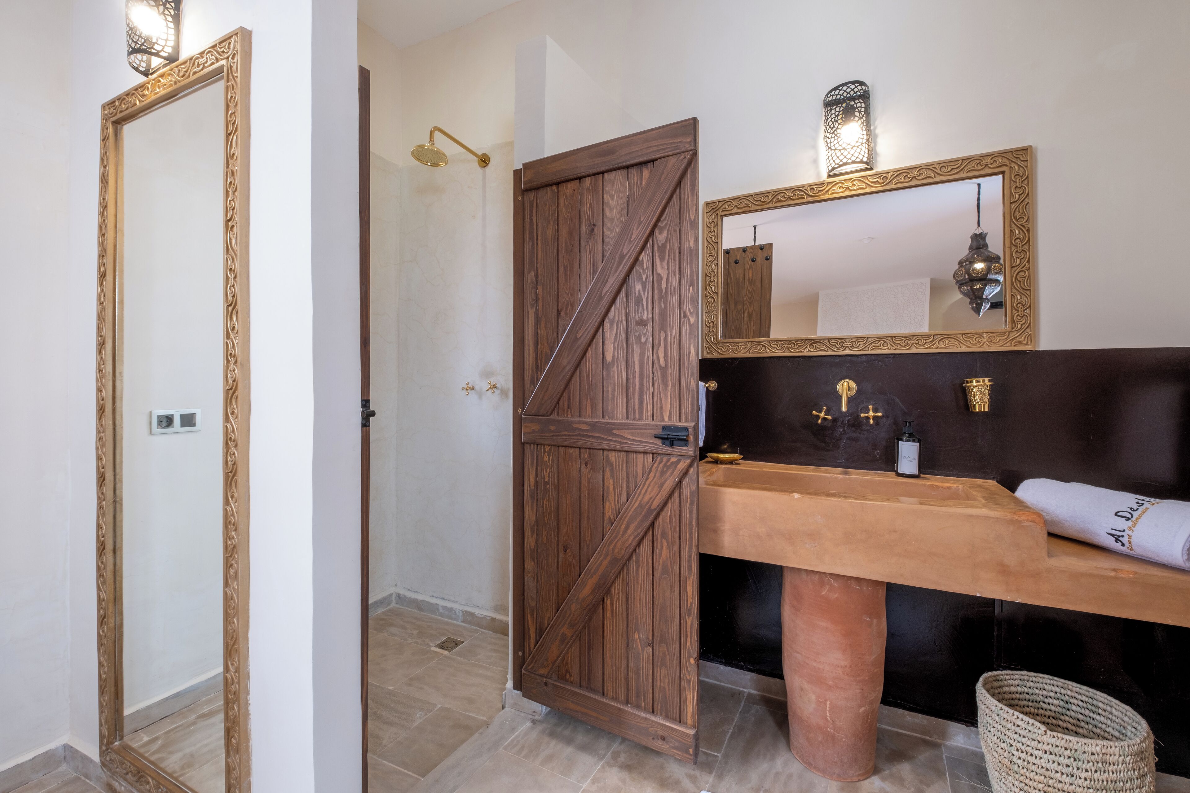 Un bagno con una porta in legno, uno specchio grande, un lavandino e un asciugamano.