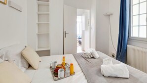 Ein Hotelzimmer mit Bett, Frühstücksbrett und Blick ins Freie.