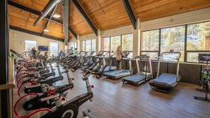 A gym with multiple cardio machines, large windows, and a wooden ceiling. - Tamarron Condo w/ Pools, Sauna & Fireplace (Durango)