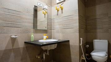 A compact bathroom with a sink, mirror, and toilet.