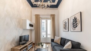 A modern living room with a TV, sofa, and artwork.