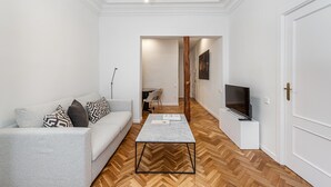 Una sala moderna con un sofá, una mesa de centro y un mueble para televisor.