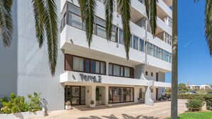 Ein mehrstöckiges Hotel mit modernem Design, mit Balkonen, großen Fenstern und einem gepflasterten Eingangsbereich.