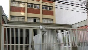 A gated entrance with a metal gate and a building in the background. - Studio Barreto Leme 72 (Campinas)