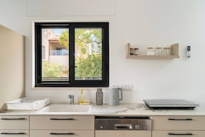 Una cocina moderna con ventana, lavavajillas Bosch y cafetera.