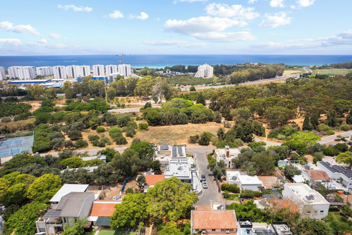 Zona residencial amb diversos edificis, un carrer i vista al mar.