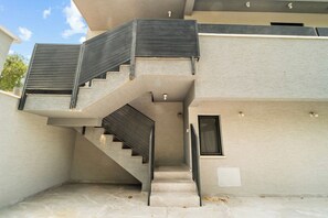 A modern staircase with a metal railing leading to an upper level.