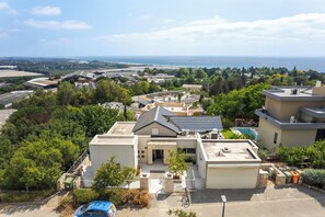 Un quartiere residenziale con una casa dotata di garage, piscina e vista sul mare.