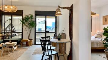 Una sala moderna con comedor, ventanas amplias y vista a la ciudad.