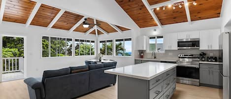 Una cocina espaciosa con una isla central, ventanas grandes y un techo de vigas de madera.