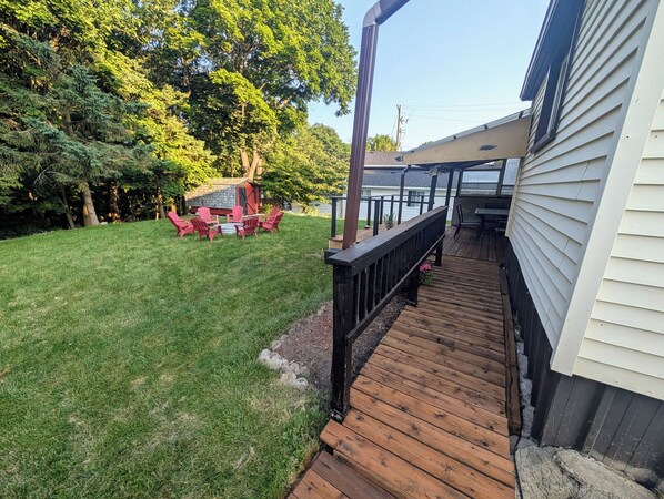 A wooden deck leading to a house with a covered patio area.