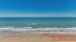 A beach with clear blue water and a sandy shore. - Beachfront & Oceanfront Views – Private Balcony (Daytona Beach)