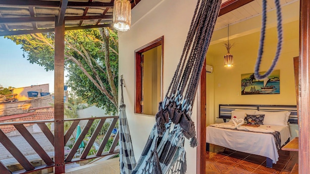 Una habitación con cama, una hamaca y vistas al exterior.