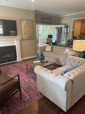 TV connectée, cheminée, livres, écrans d'ordinateur