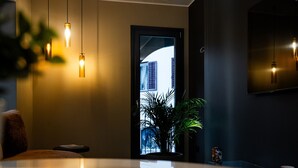 A modern interior with pendant lighting, a potted plant, and a view through a door.