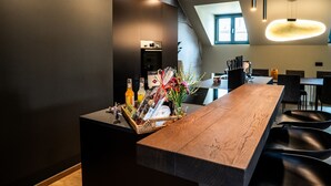 Een moderne keuken met een houten kookeiland, zwarte barkrukken en een inbouwoven.