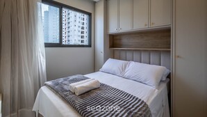 A bedroom with a bed, a window, and a wardrobe. - Apart With Barbecue 600m From the Beach Aqt0604 (Itapema)