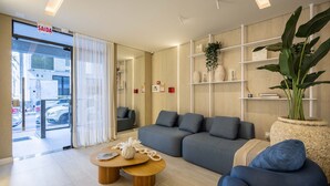 A modern living room with a sofa, a coffee table, and a large plant. - Apart With Barbecue 600m From the Beach Aqt0604 (Itapema)
