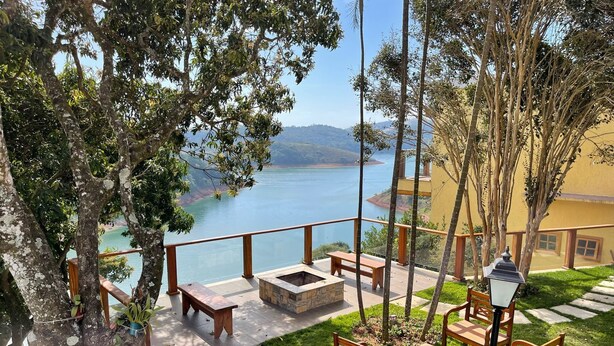 A terrace with wooden benches and tables, overlooking a lake and mountains. - Beautiful farm in Igarata right on the dam. (Canto das Águas Igaratá)