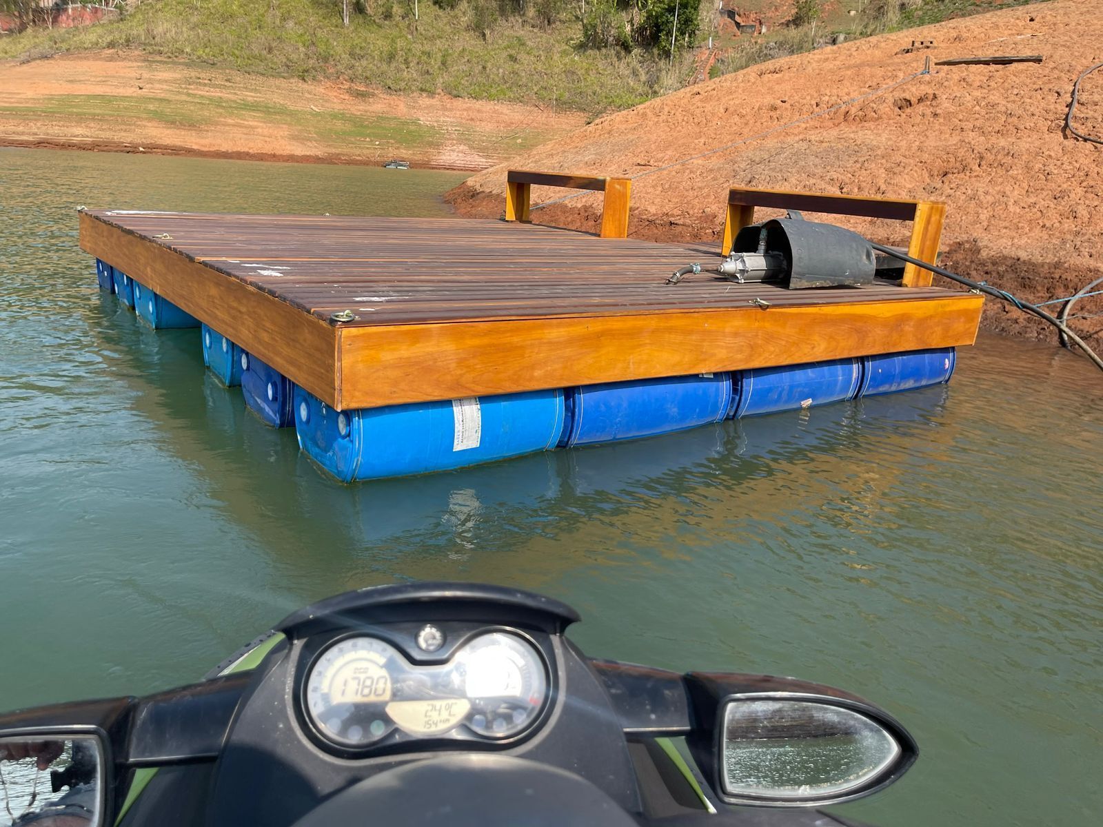 Un molo di legno che si protende in una distesa d'acqua, con una barca a motore nelle vicinanze.