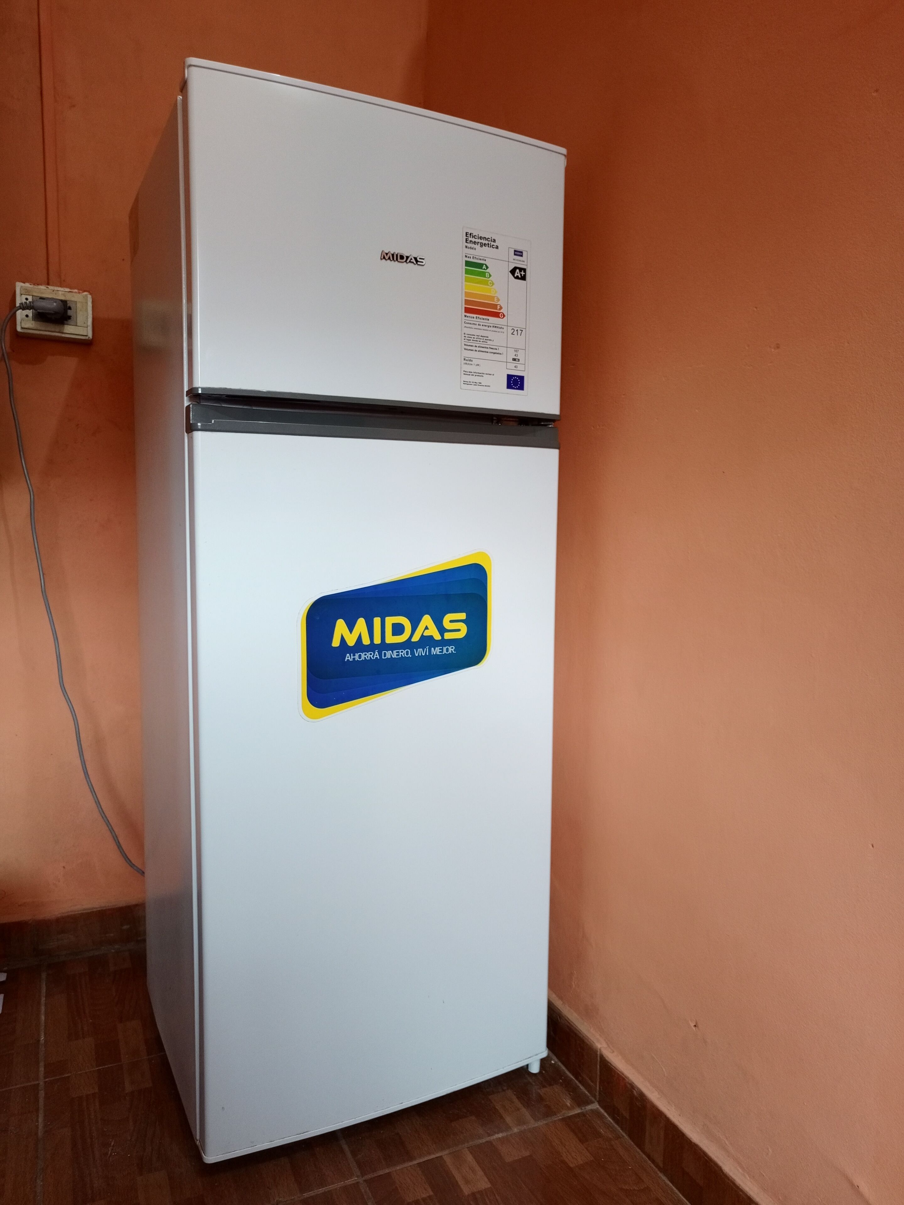 Frigorifero bianco con adesivo che riporta 'MIDAS' ed etichetta che indica l'efficienza energetica.