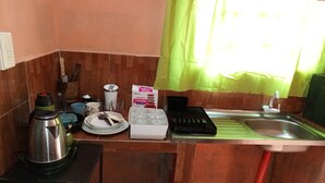 A small kitchen with a sink, a kettle, a toaster, and various kitchen utensils. - Apartment in Encarnación (WRC 2025) (Encarnación)