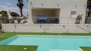 A modern building with a swimming pool, a covered area, and a clear sky. - Villa Rosy - Your Villa Near the Sea (Marina di Butera)