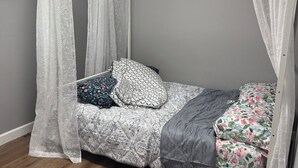 A four-poster bed with a canopy, a patterned bedspread, and multiple pillows. - 3-bedroom house in fabulous St. Louis with AC (St. Louis)