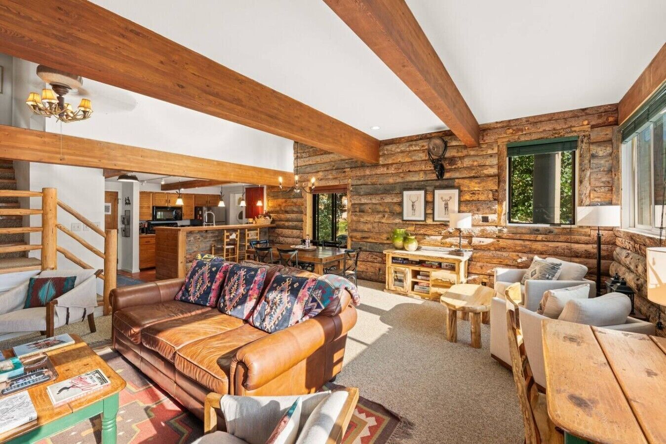 Interior d'una cabana de fusta amb saló, menjador i cuina.
