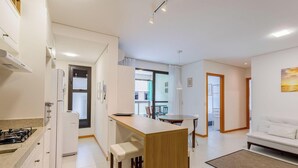 A modern, well-lit apartment with a kitchen, dining area, and living room. - Modern apt With Pool Near the Beach Avr0203 (Penha)