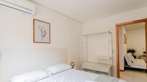 A bedroom with a bed, a bedside table, a nightstand, a wardrobe, a chair, and a mirror. - Modern apt With Pool Near the Beach Avr0203 (Penha)