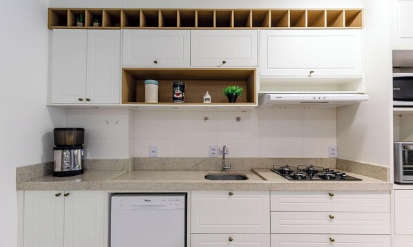 Una cocina moderna con armarios blancos, una estufa integrada y un lavavajillas.