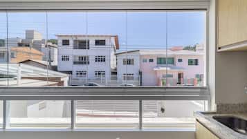 A modern kitchen with a large window overlooking a residential area.