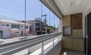 A modern kitchen with a large window overlooking a street.