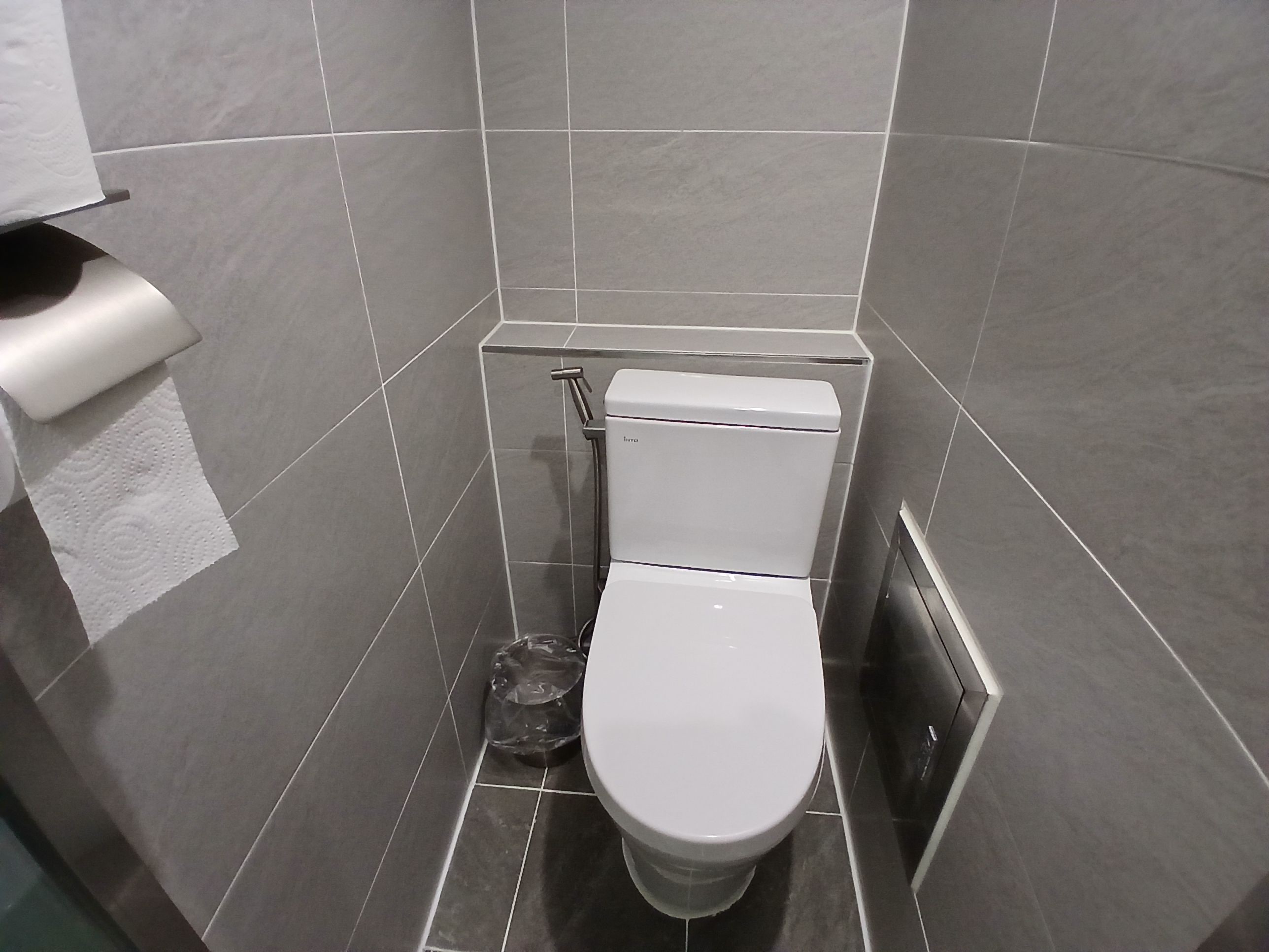 Un bagno piccolo con il water, un asciugamani ad aria e un cestino.