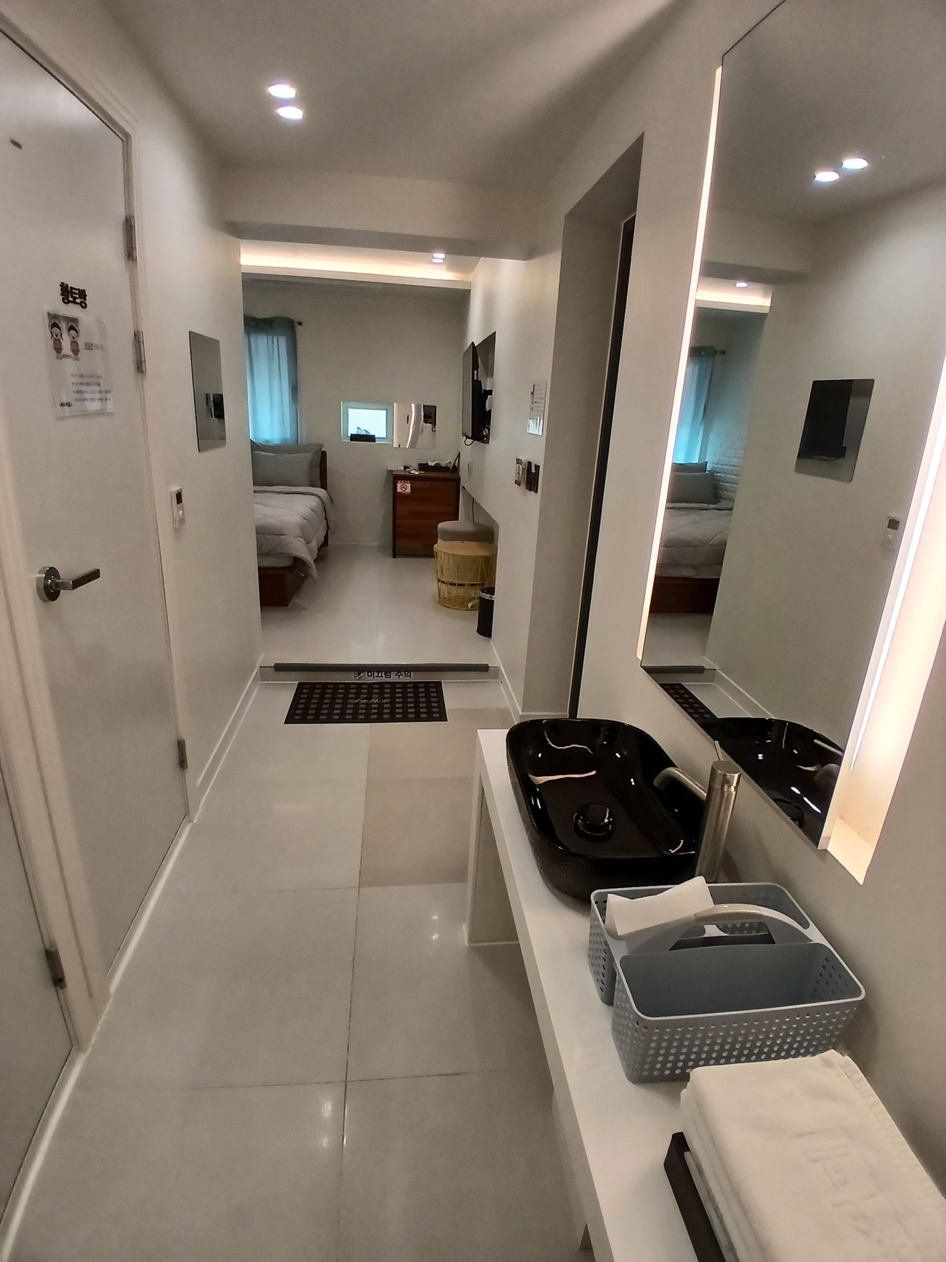 Une chambre d’hôtel comprenant un lit, un bureau, un miroir et une salle de bain.