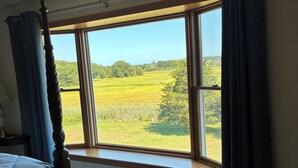 A bedroom with a large window, a bed, and a patterned rug. - Winter deal! Delightful 3-4 bed one floor, 3 baths, fireplace  (Essex)