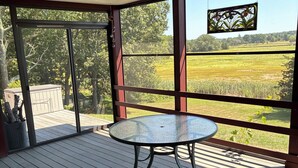 A covered outdoor area with a glass table and chairs, large windows offering a view of a green landscape. - Winter deal! Delightful 3-4 bed one floor, 3 baths, fireplace  (Essex)