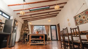 A spacious kitchen with a stone wall, wooden beams, and a large window. - Family friendly 5-bedroom home in the Sacred Valley (Calca)
