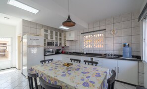 A modern kitchen with a dining table, cabinets, and a water dispenser.