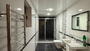 A modern bathroom with a glass shower enclosure, a vanity with a mirror, and a toilet. - Sheyx Plaza (Tashkent)