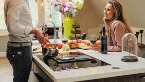 Une cuisine moderne dotée d’un îlot central, d’un coin repas et offrant une vue sur l’extérieur.