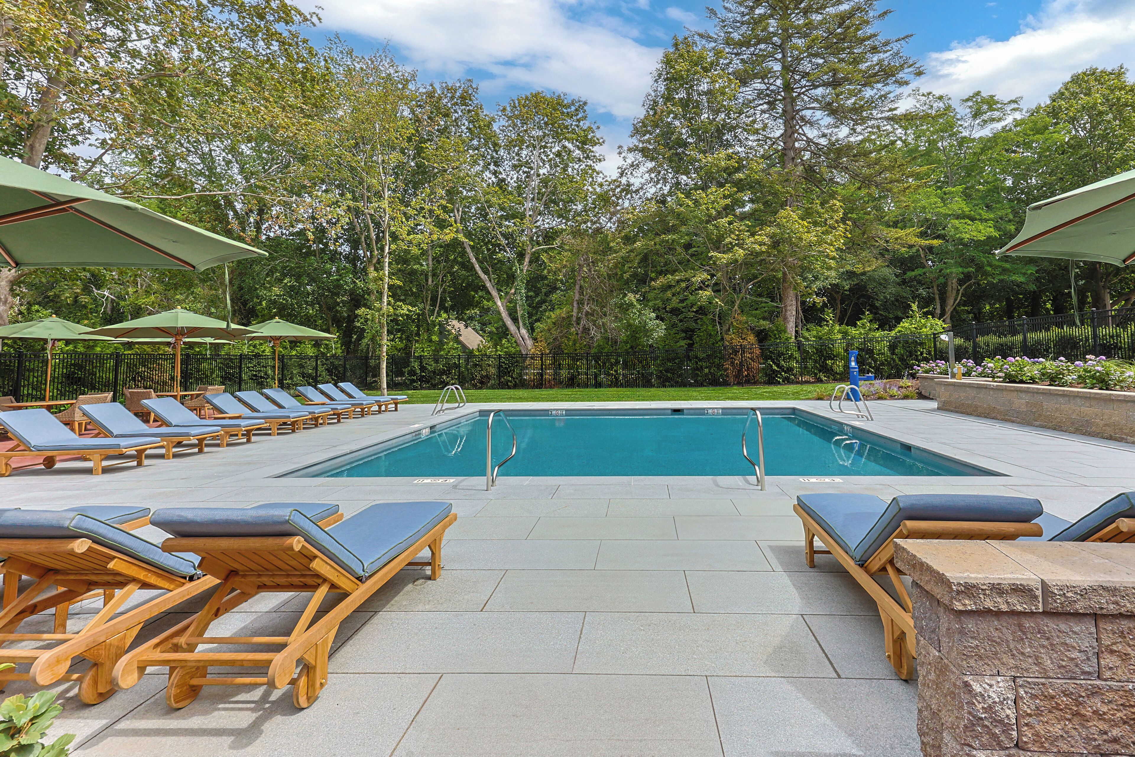 Una piscina al aire libre de temporada, sombrillas